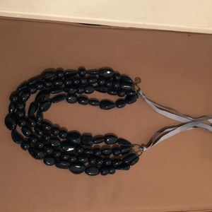 Dark blue resin necklace with satin straps.